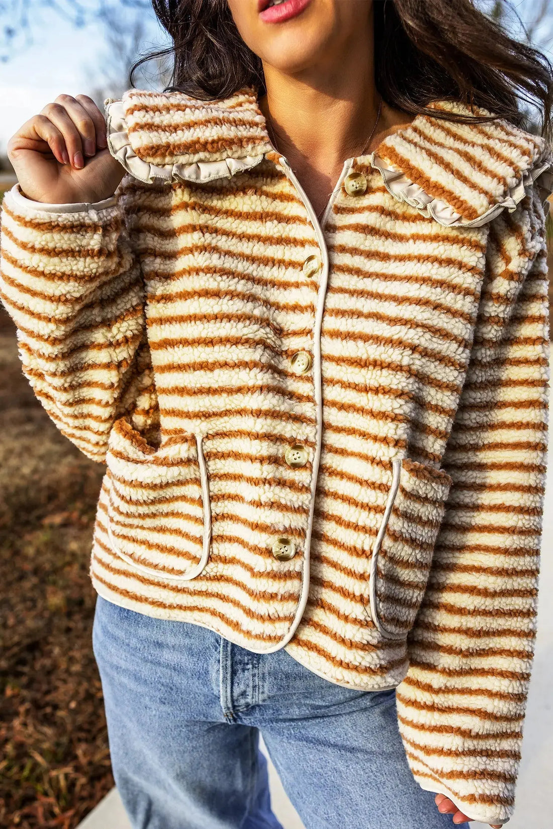 Brown stripe fleece button front jacket from Nataliz styled on a model, front view showing the ruffled collar and decorative buttons