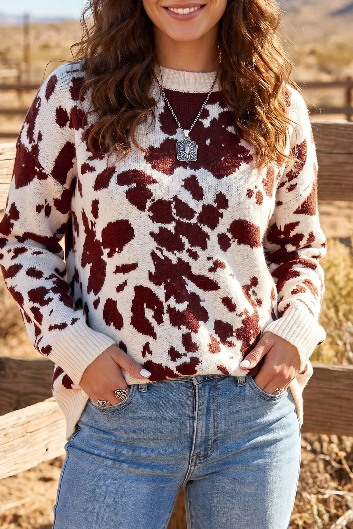 Brown cow print long sleeve pullover knit sweater model front view · nz-alt-v1