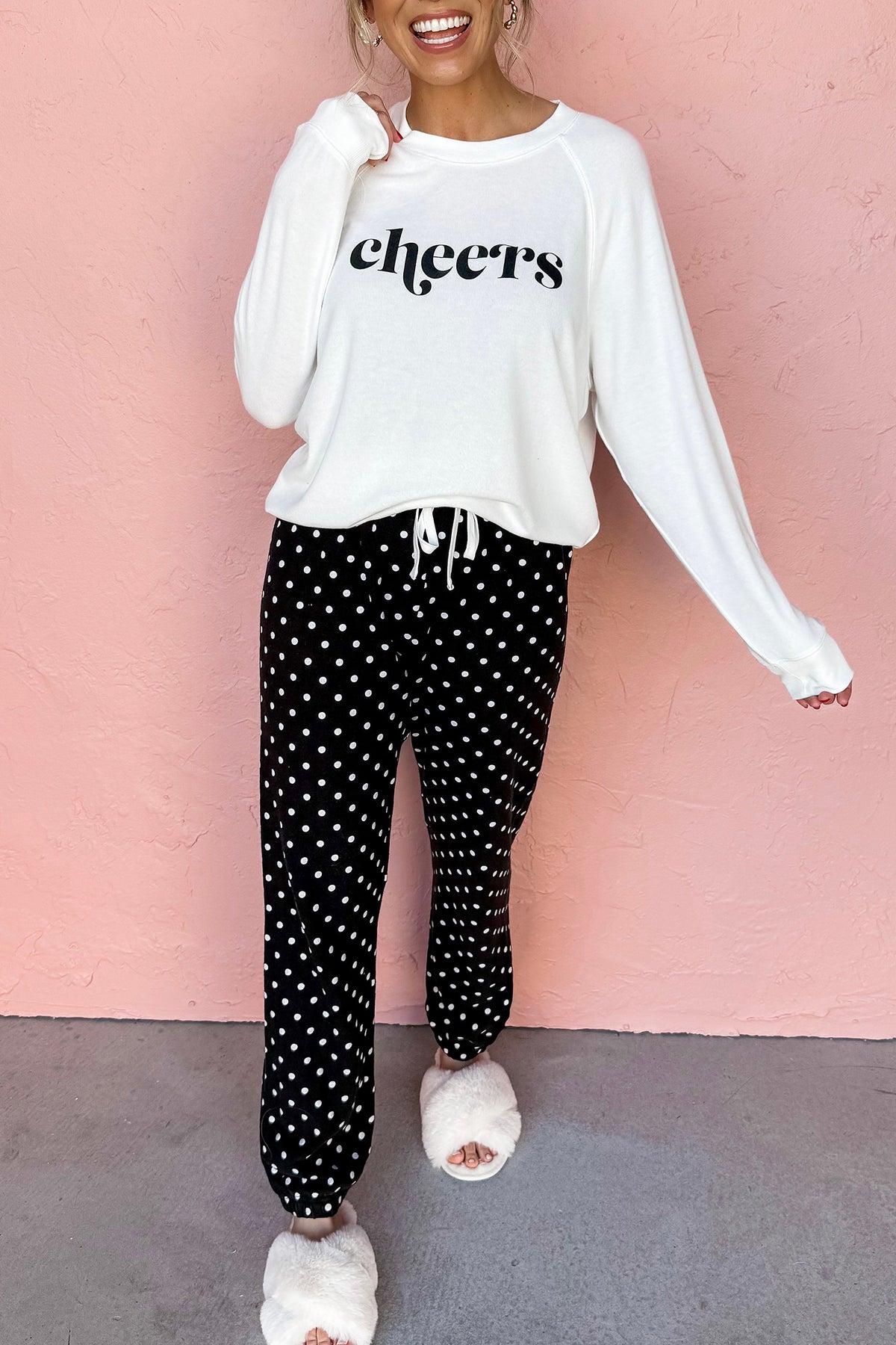 Black cheers graphic raglan pullover and polka dot pants loungewear set, model front view · nz-alt-v1