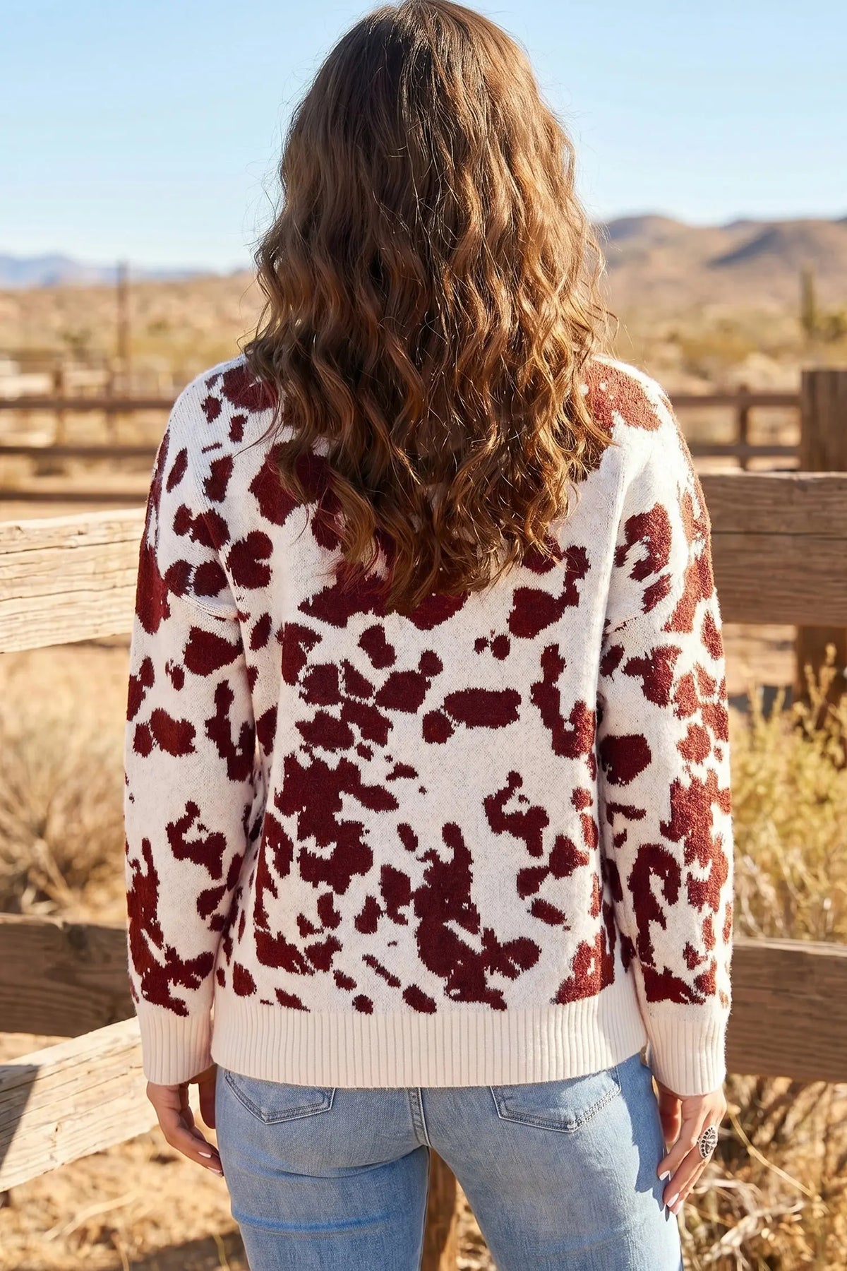 Brown cow print long sleeve pullover knit sweater model back view · nz-alt-v1