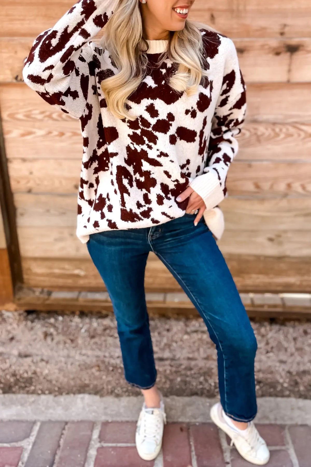 Brown cow print long sleeve pullover knit sweater model front view · nz-alt-v1