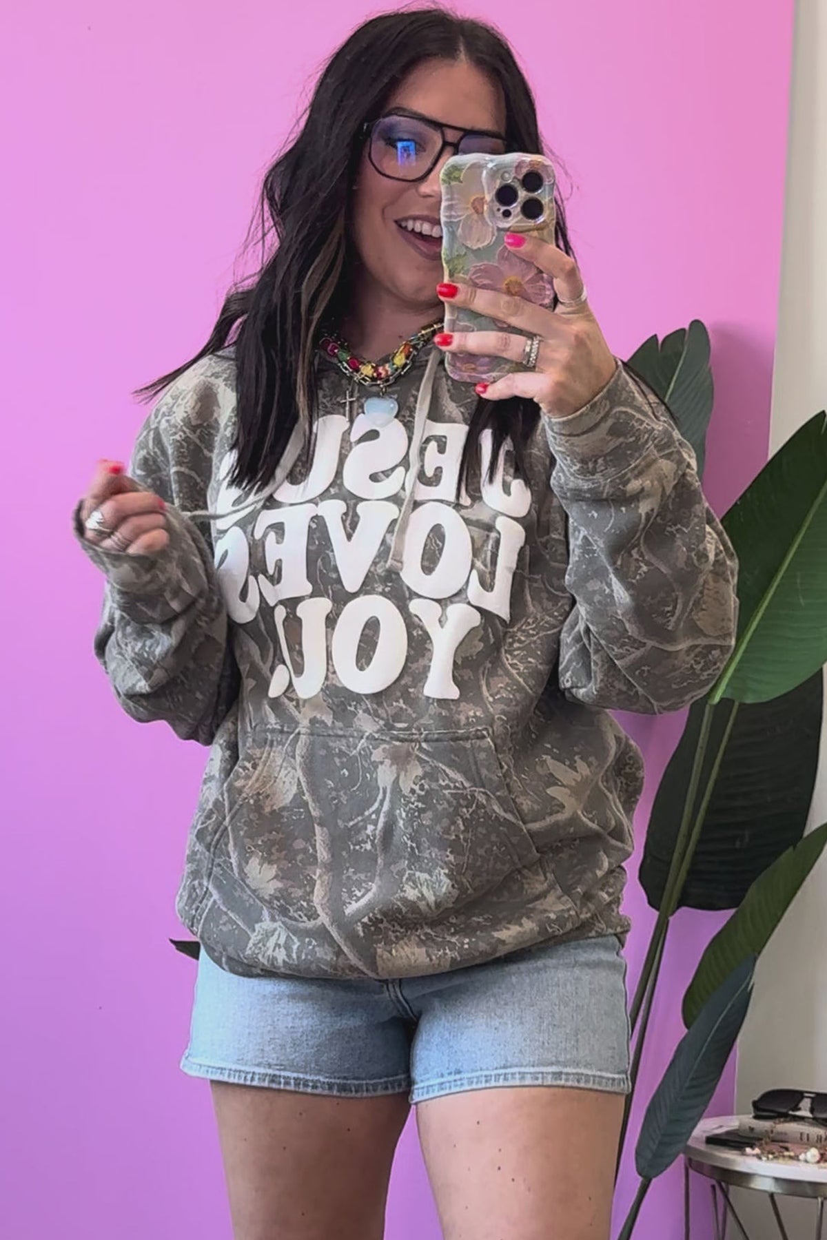 Multicolour camouflage Jesus Loves You print relaxed hoodie model front view · nz-alt-v1