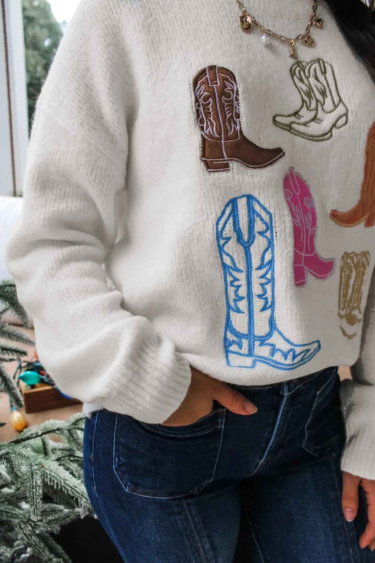 White sweater with embroidered cowboy boots graphic, detail view · nz-alt-v1