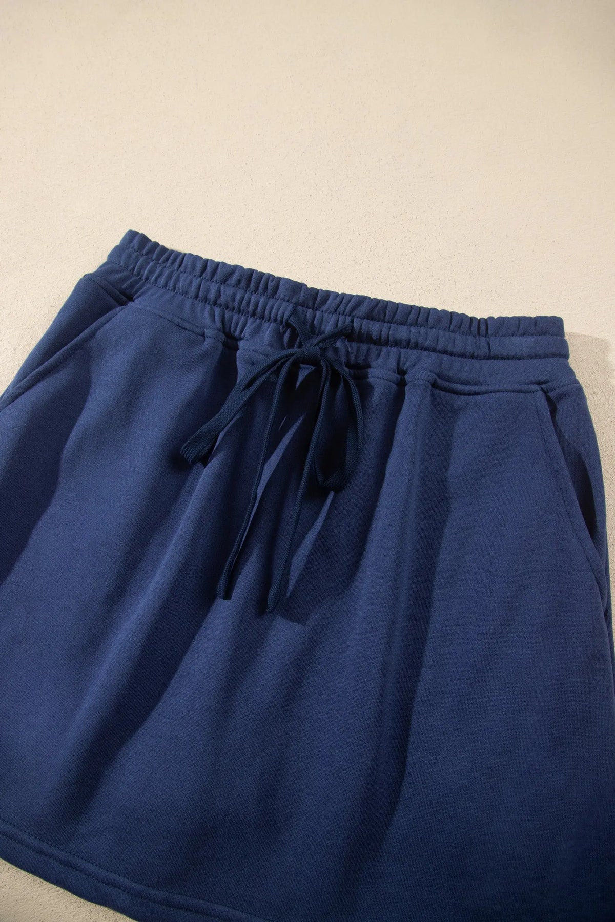 Navy blue long sleeve zip-up top elastic waist skort set flat lay view · nz-alt-v1