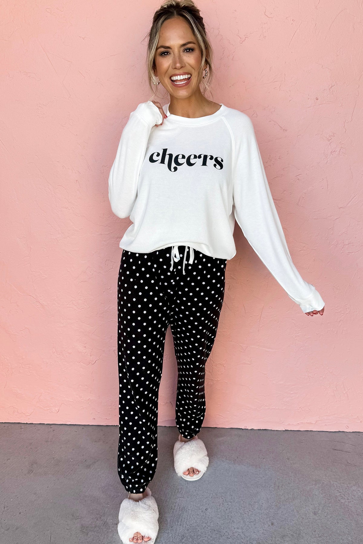 Black cheers graphic raglan pullover and polka dot pants loungewear set, model front view · nz-alt-v1